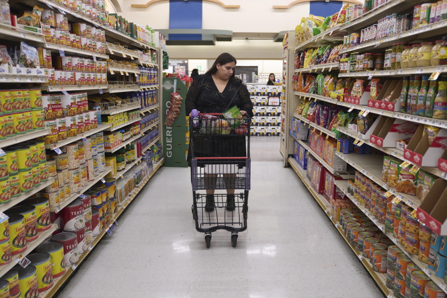 Jaqueline Benitez pushes her cart down an aisle as she shops for groceries at a supermarket in Bellflower, Calif., on Monday, Feb. 13, 2023. Benitez, 21, who works as a preschool teacher, depends on California's SNAP benefits to help pay for food, and starting in March she expects a significant cut, perhaps half, of the $250 in food benefits she has received since 2020.