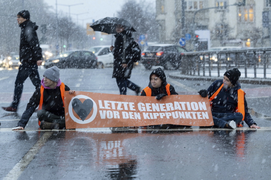 FILE - Activists of the "Last Generation" stick themselves on a street during snowfall in Dresden, Germany, and want to draw attention to the compliance with the climate targets, Friday, Jan. 20, 2023. The German city of Hannover has reached an agreement with climate activists to stop blocking roads, after its mayor announced Thursday, Feb. 23, 2023, that he supports several of their demands.