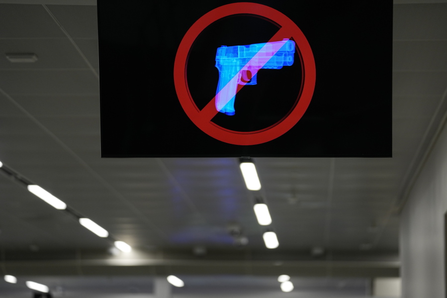 A television displays a "no guns" sign at the Transportation Security Administration security area at the Hartsfield-Jackson Atlanta International Airport on Wednesday, Jan. 25, 2023, in Atlanta. Last year saw a record number of guns intercepted at airport checkpoints across the country. The numbers have been steadily climbing and hit 6,542 last year.
