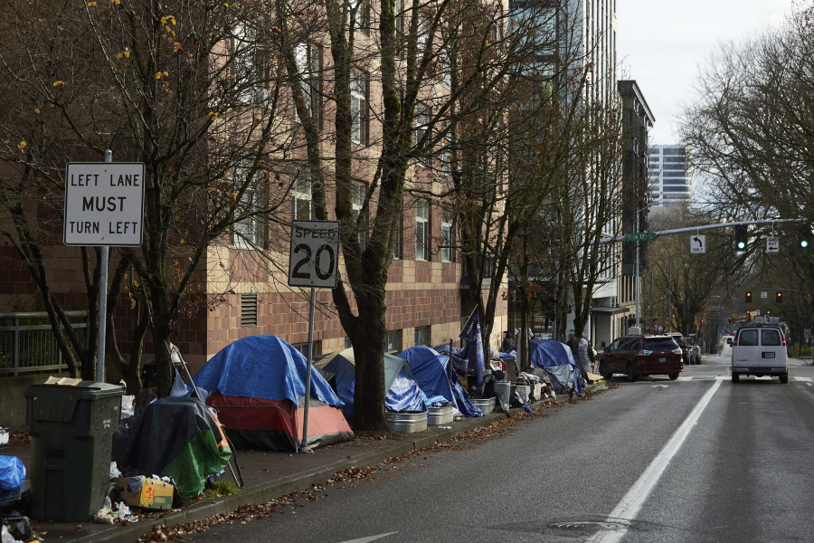 FILE - Homeless tents line the sidewalk on SW Clay St in Portland, Ore., on Dec. 9, 2020. Democratic lawmakers in Oregon have proposed a $200 million spending package to tackle two of their top issues--homelessness and housing--as the state struggles to build more homes and move a growing number of people off the streets.