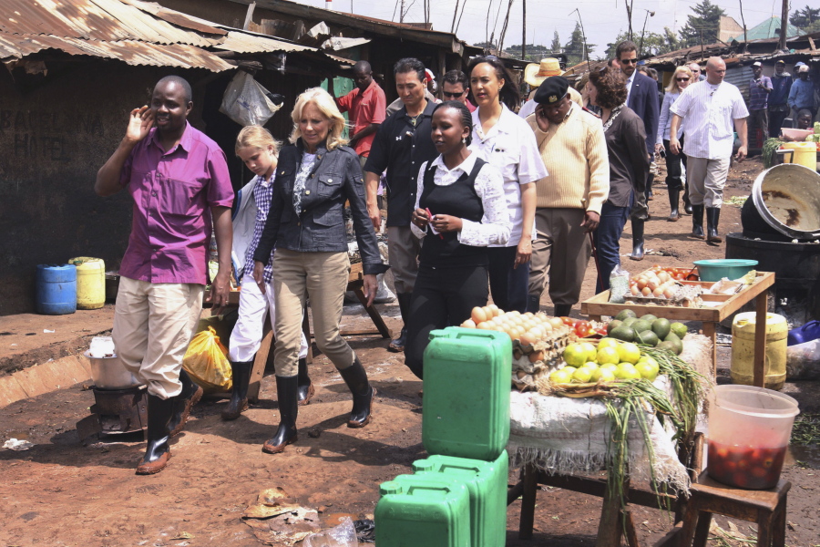 FILE - Jill Biden, wife of then-Vice President Joe Biden, third left, and her granddaughter Maisy, 9, second left, walk past a food stall as they visit the Kibera slums in Nairobi, Kenya June 8, 2010. Jill Biden is not a newcomer to Africa. It will be her sixth time in Africa when she arrives in Namibia on Wednesday as part of a commitment by President Joe Biden to deepen U.S. engagement with region.