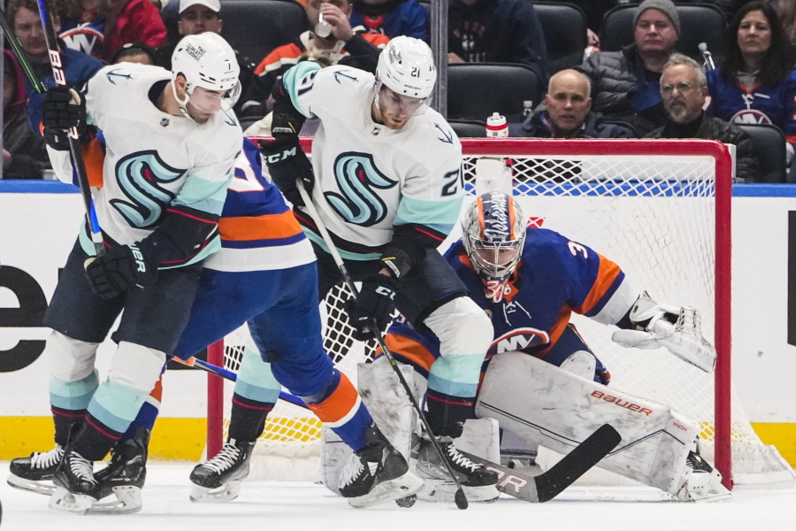 New York Islanders goaltender Ilya Sorokin (30) protects his net from Seattle Kraken's Jordan Eberle (7) and Alex Wennberg (21) during the second period of an NHL hockey game Tuesday, Feb. 7, 2023, in Elmont, N.Y.
