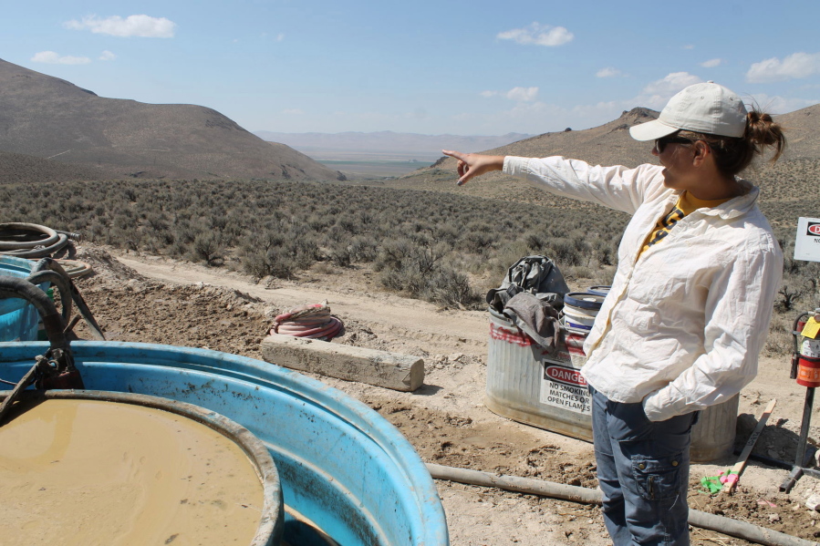 FILE - Melissa Boerst, a Lithium Nevada Corp. geologist, points to an area of future exploration from a drill site at the Thacker Pass Project in Humboldt County, Nev., on Sept. 13, 2018. A federal judge on Monday, Feb. 6, 2023, ordered the government to revisit part of its environmental review of a lithium mine planned in Nevada but denied opponents' effort to block the project in a ruling the developer says clears the way for construction at the largest known U.S. lithium deposit.