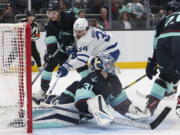 Toronto Maple Leafs center Auston Matthews (34) scores a goal as Seattle Kraken goaltender Philipp Grubauer (31) and defenseman Will Borgen (3) defend during the second period of an NHL hockey game Sunday, Feb. 26, 2023, in Seattle.
