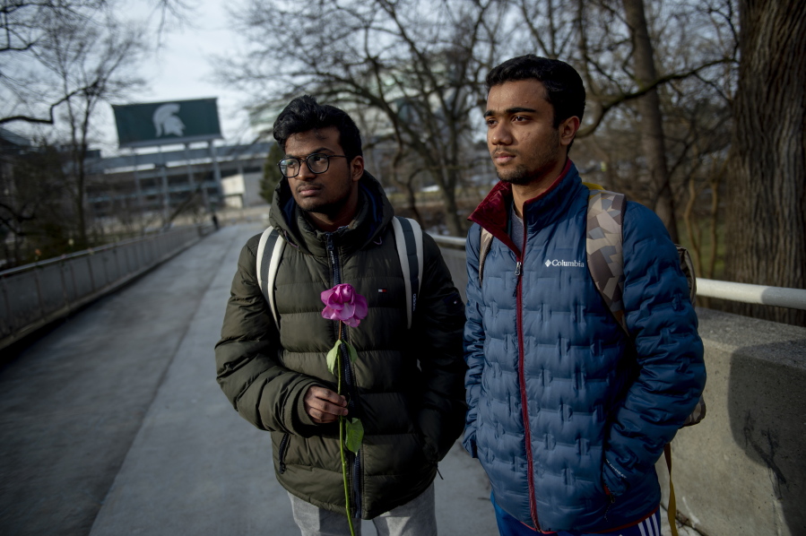 Michigan State international students Dheeraj Thota, left, and Chirag Bhansari, both freshman studying computer science, found a single rose on their walk to class as campus opens back up for the first day of classes on Monday, Feb. 20, 2023 at Michigan State University in East Lansing, Mich.  Michigan State University is set to return to classes Monday, with officials saying they hope a return to familiarity may help the community heal.