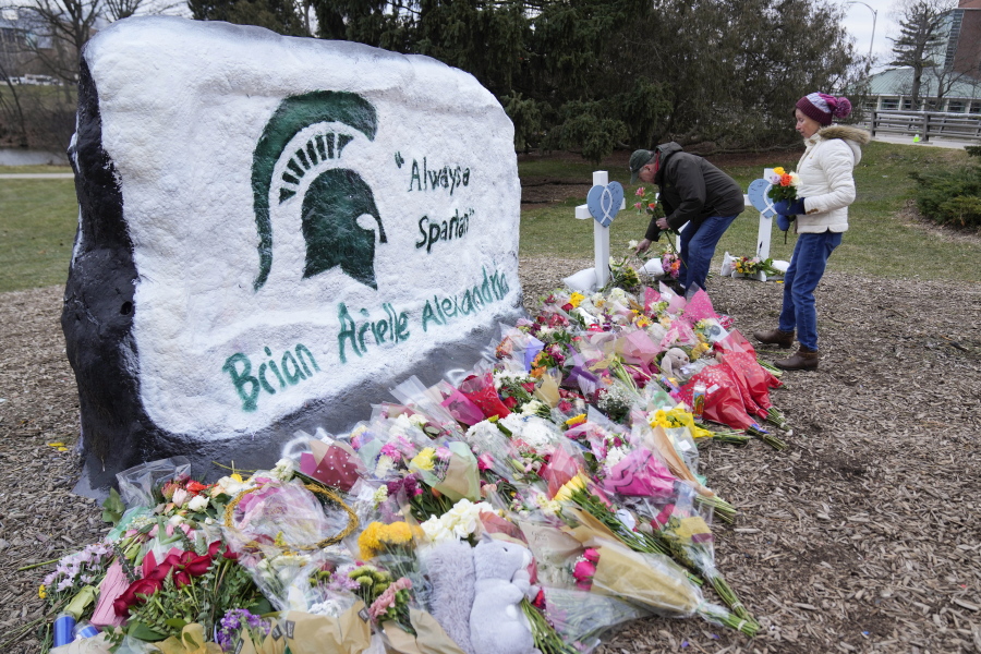 Mourners leave flowers at The Rock on the grounds of Michigan State University in East Lansing, Mich., Wednesday, Feb. 15, 2023. Alexandria Verner, Brian Fraser and Arielle Anderson were killed and several other students remain in critical condition after a gunman opened fire on the campus of Michigan State University Monday night.
