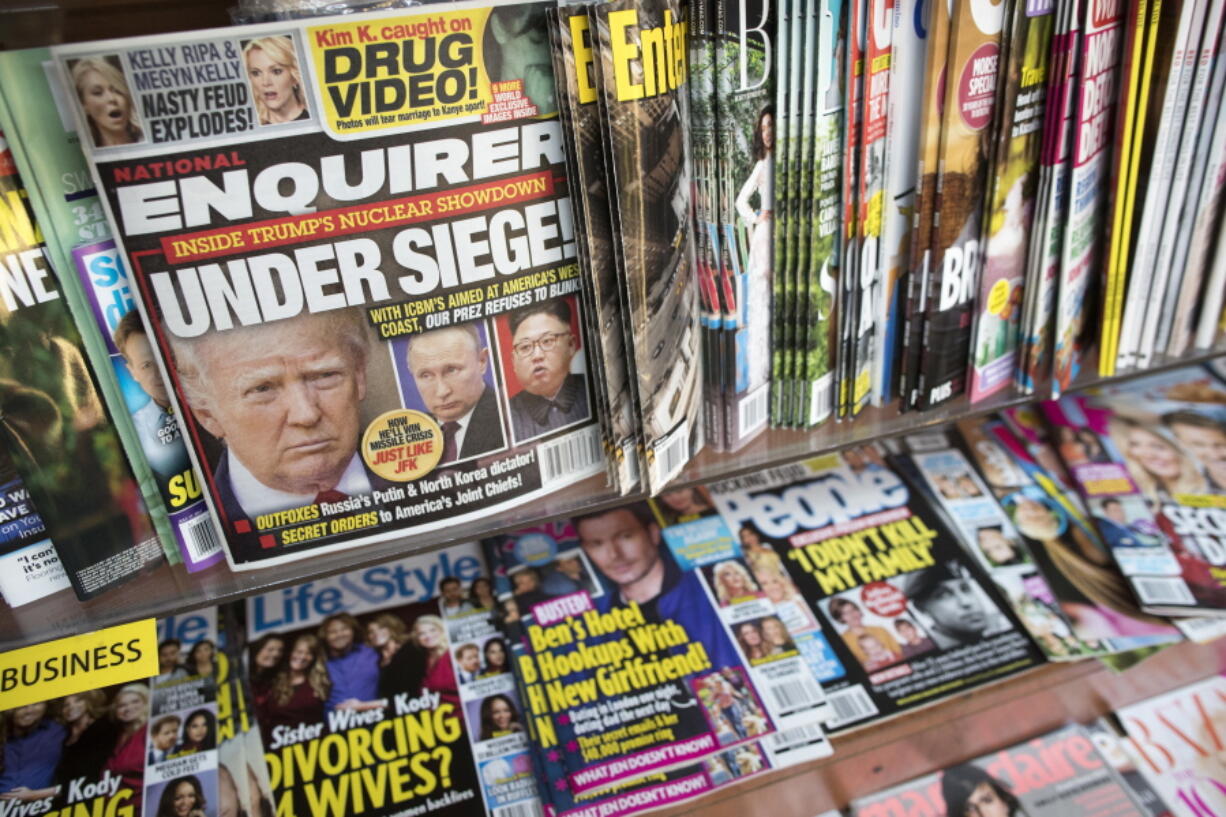 FILE - In this July 12, 2017 file photo, an issue of the National Enquirer featuring President Donald Trump on its cover is displayed on a newsstand in a store in New York. VVIP Ventures is buying the U.S. and U.K editions of the National Enquirer, the tabloid that engaged in "catch-and-kill" practices to bury stories about Donald Trump during his presidential campaign. Financial terms were not disclosed.