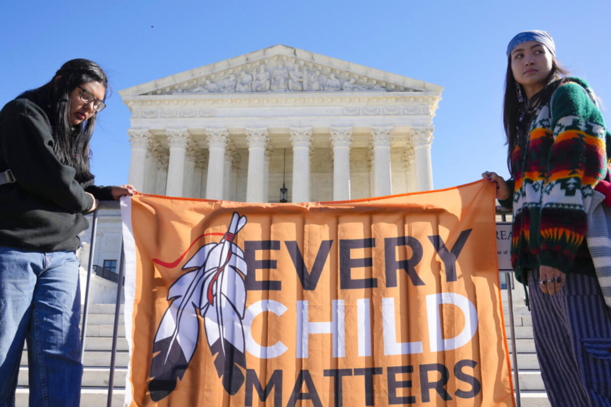 FILE - Demonstrators stand outside of the U.S. Supreme Court, as the court hears arguments over the Indian Child Welfare Act on Nov. 9, 2022, in Washington. Montana is one of a handful U.S. states considering legislation this year to include provisions of the Indian Child Welfare Act in state law.