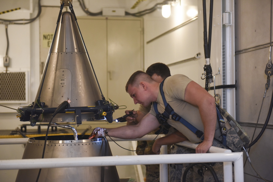 In this image provided by the U.S. Air Force, Senior Airmen Andrew Whitener and Tyler Glodgett 341st Missile Maintenance Squadron topsiders, inspect the cable connections of an intercontinental ballistic missile during a Simulated Electronic Launch-Minuteman test Sept. 22, 2020, at a launch facility near Great Falls, Mont. The top Air Force officer in charge of the nation's air and ground-launched nuclear missiles has requested an official investigation into the number of officers who are reporting the same type of blood cancer after serving at Malmstrom Air Force Base. (Tristan Day/U.S.