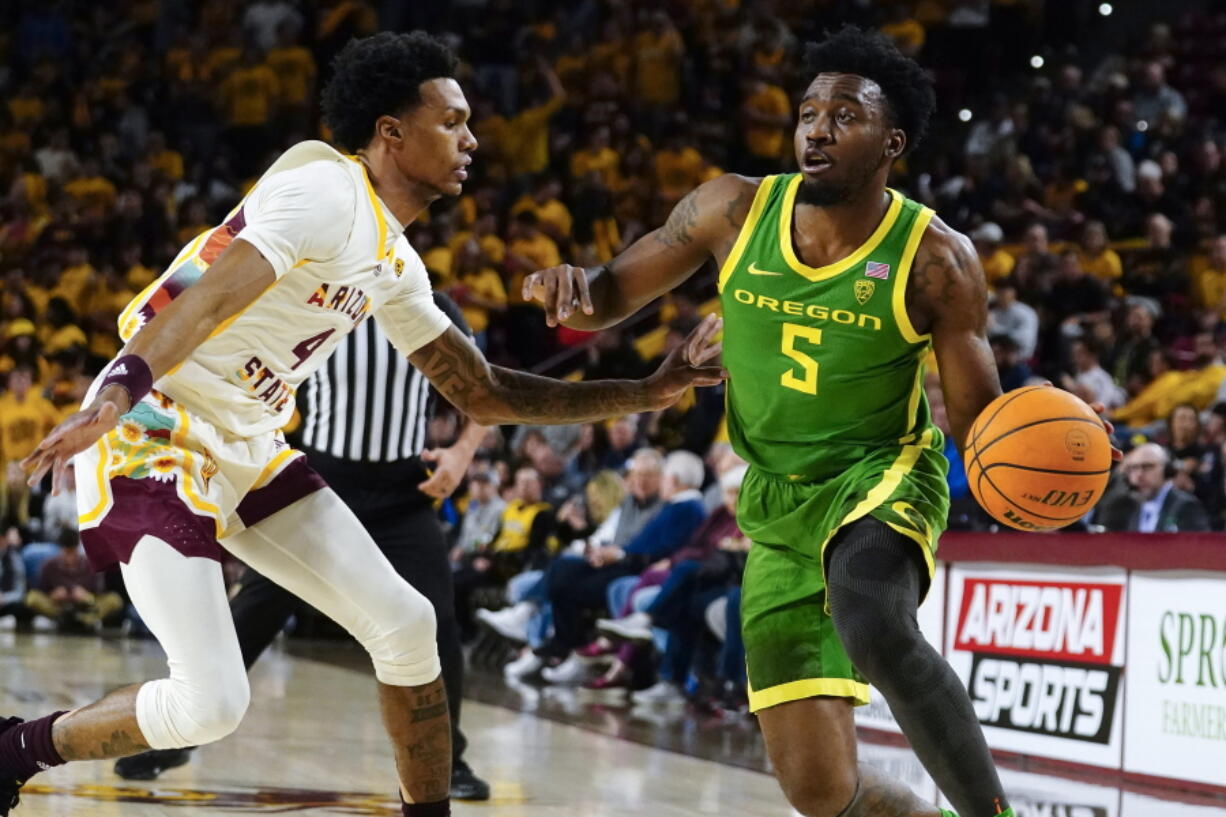 Oregon's Jermaine Couisnard (5) drives around Arizona State's Desmond Cambridge Jr. (4) during the first half of an NCAA college basketball game, Saturday, Feb. 4, 2023, in Tempe, Ariz.