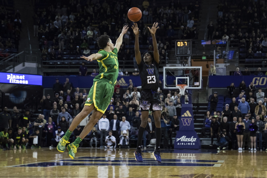 Washington guard Keyon Menifield shoots over Oregon guard Will Richardson during the second half of an NCAA college basketball game Wednesday, Feb. 15, 2023, in Seattle.