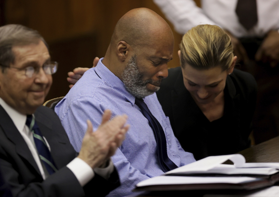 Lamar Johnson, center, and his attorneys react on Tuesday, Feb. 14, 2023, after St. Louis Circuit Judge David Mason vacated his murder conviction during a hearing in St. Louis, Mo. Johnson served nearly 28 years of a life sentence for a killing that he has always said he didn't commit. (Christian Gooden/St.