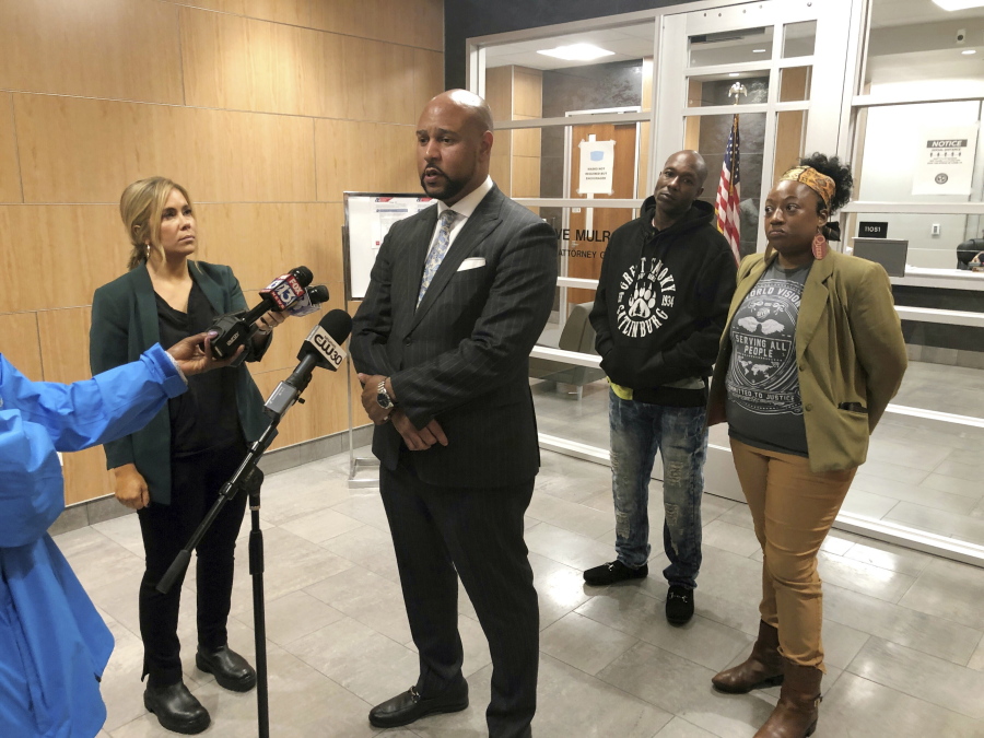 Carlos E. Moore, at microphone, speaks with reporters outside the Shelby County district attorney's office on Thursday, Feb. 16, 2023, in Memphis, Tenn. Moore and Henry Williams, back left, have asked the district attorney to reopen the case of Williams' son, Darrius Stewart, who was 19 when he was fatally shot by a Memphis police officer during an attempted arrest in 2015. Also pictured is activist Pamela Moses, right.