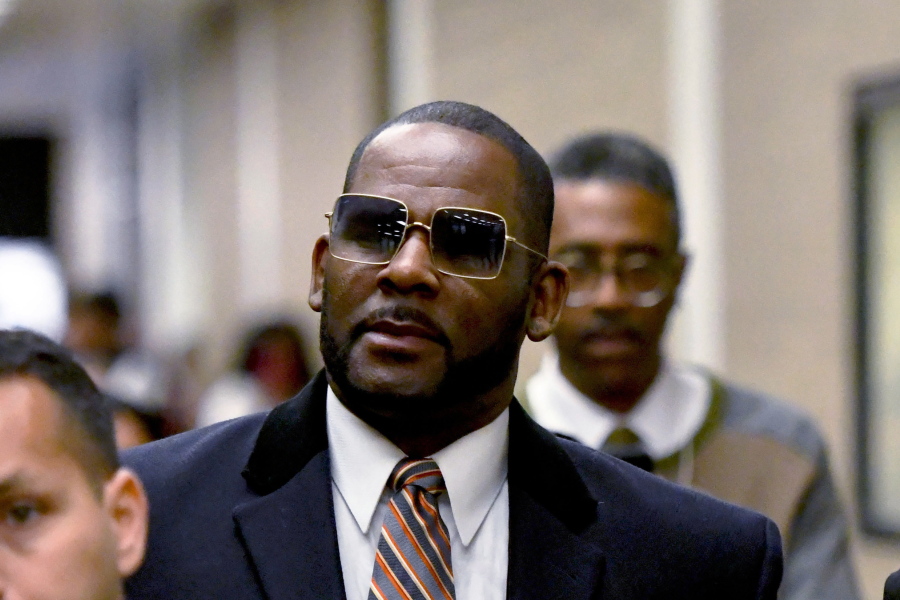 FILE - R. Kelly, center, leaves the Daley Center after a hearing in his child support case May 8, 2019, in Chicago. Federal prosecutors asked a judge Thursday, Feb. 16, 2023, to give singer R. Kelly 25 more years in prison for his child pornography and enticement convictions last year in Chicago, which would add to 30 years he recently began serving in a New York case.