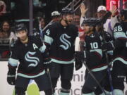 Seattle Kraken right wing Jordan Eberle (7) celebrates his second goal of the night against the Detroit Red Wings with Jamie Oleksiak (24) and Matty Beniers (10), during the second period of an NHL hockey game Saturday, Feb. 18, 2023, in Seattle.
