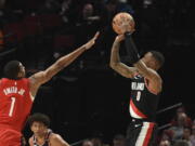 Portland Trail Blazers guard Damian Lillard, right, hits a basket over Houston Rockets forward Jabari Smith Jr., left, during the first half of an NBA basketball game in Portland, Ore., Sunday, Feb. 26, 2023.