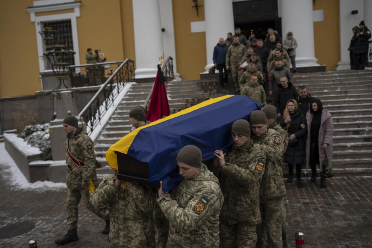Soldiers carry the coffin of Eduard Strauss, a Ukrainian serviceman who died in combat on Jan. 17 in Bakhmut, during a farewell ceremony in Kyiv, Ukraine, Monday, Feb. 6, 2023.
