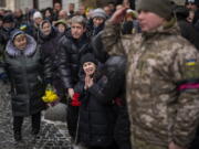 Anastasia, center, cries as soldiers carry the coffin of her brother Oleg Kunynets, a Ukrainian military servicemen who were killed in the east of the country, during his funeral in Lviv, Ukraine, Tuesday, Feb 7, 2023.