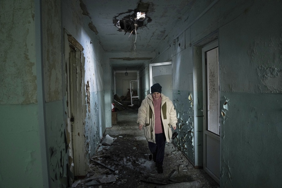 Valentyna Mozgova, 55, a lab medic walks in the corridor of a hospital which was damaged by Russian shelling in Krasnohorivka, Ukraine, Sunday, Feb. 19, 2023. A year into Russia's war in Ukraine, researchers have documented more than 700 attacks against health care facilities and staff. The data was verified by five organizations working in Ukraine and released Tuesday.
