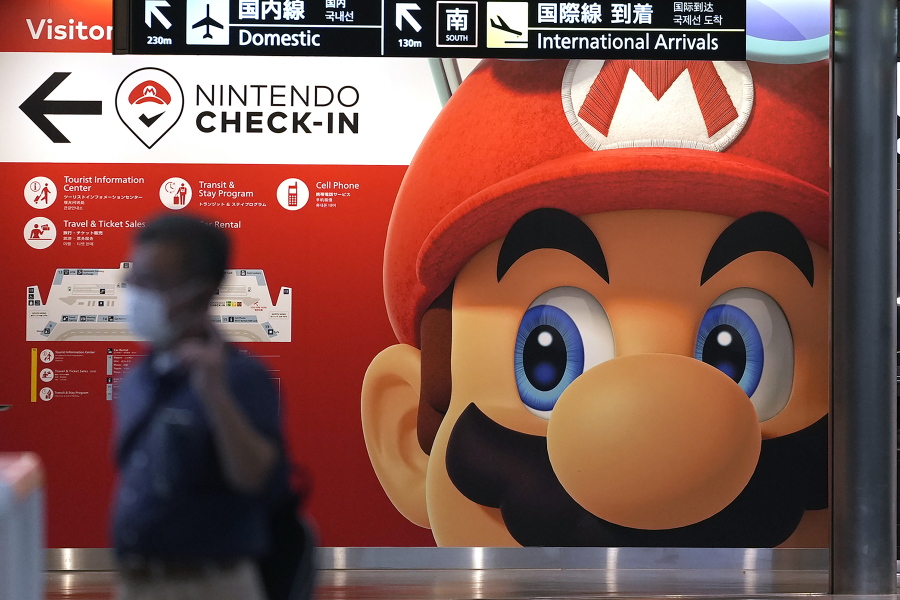 FILE - A traveler walks past an advertisement featuring a Nintendo character at Narita airport in Narita near Tokyo Friday, June 10, 2022. A Saudi sovereign wealth fund now holds 8.26% of the stock in the video game maker Nintendo, making it the largest outside investor in the Japanese gaming company, a company filing said Friday, Feb. 17, 2023.