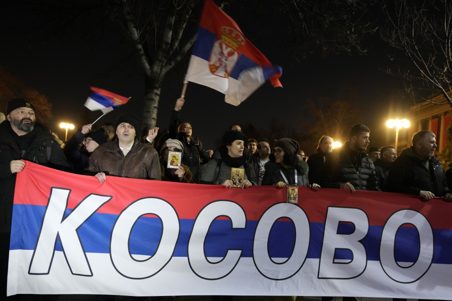 People hold a Serbian flag reading "Kosovo" during a protest against the Serbian authorities and French-German plan for the resolution of Kosovo, in Belgrade, Serbia, Wednesday, Feb. 15, 2023. Hundreds of pro-Russia nationalists have rallied outside the Serbian presidency building demanding that President Aleksandar Vucic reject a Western plan for normalization of ties with breakaway Kosovo and pull out of negotiations. Shouting "Treason" and carrying banners reading "No surrender," the protesters on Wednesday blocked traffic in a busy street by the presidency.