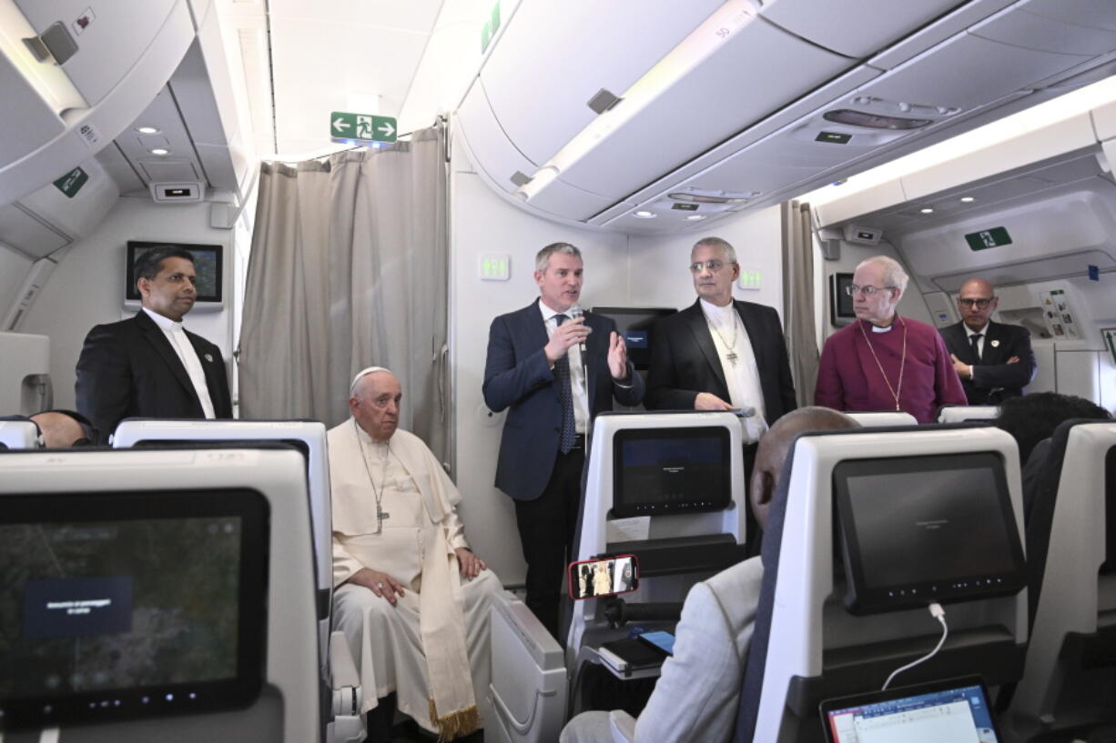 The Archbishop of Canterbury Justin Welby, right, Pope Francis,left, and the Moderator of the General Assembly of the Church of Scotland Iain Greenshields meet the journalists during an airborne press conference aboard the airplane directed to Rome, at the end of his pastoral visit to Congo and South Sudan, Sunday, Feb. 5, 2023.