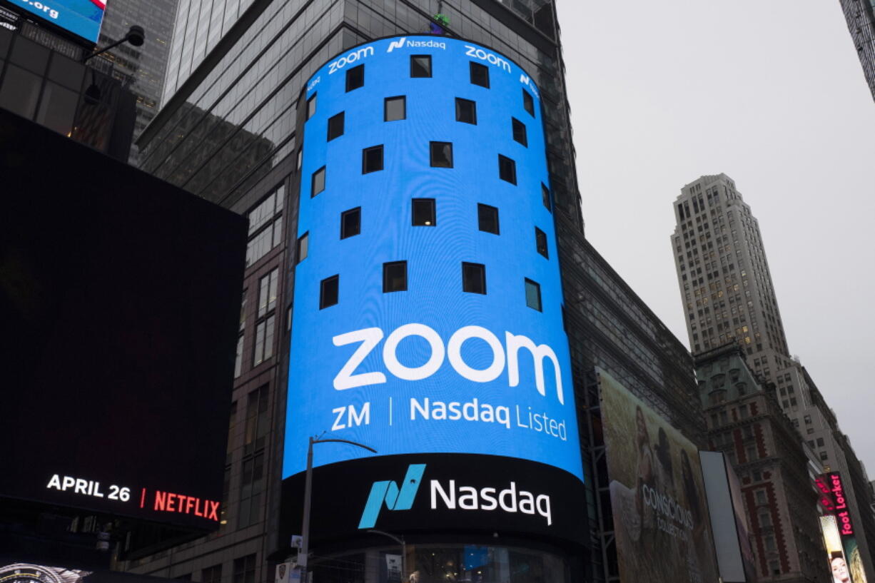 FILE - This April 18, 2019, file photo shows a sign for Zoom Video Communications ahead of the company's Nasdaq IPO in New York.  The video-conferencing service is cutting about 1,300 jobs, or approximately 15 percent of its workforce. CEO Eric Yuan said in a blog post Tuesday, Feb. 7, 2023, that the company ramped up staffing during the COVID-19 pandemic, when businesses became increasingly reliant on its service as people worked from home. Yuan said Zoom grew three times in size within 24 months to manage demand.