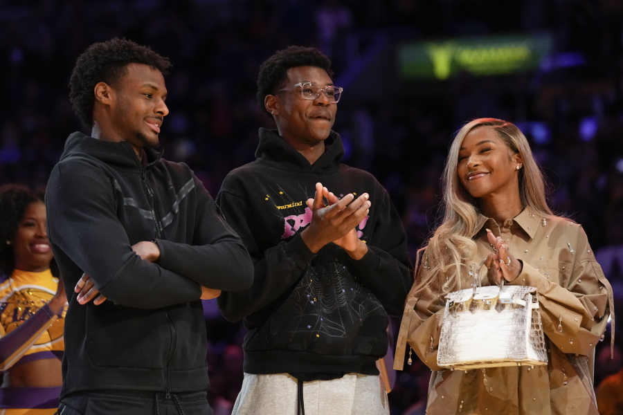 From left, Bronny James, Bryce James, and Savannah James applaud during a ceremony honoring Los Angeles Lakers forward LeBron James as the NBA's all-time leading scorer before an NBA game against the Milwaukee Bucks on Thursday, Feb. 9, 2023, in Los Angeles. James passed Kareem Abdul-Jabbar to earn the record during Tuesday's NBA game against the Oklahoma City Thunder. (AP Photo/Mark J.