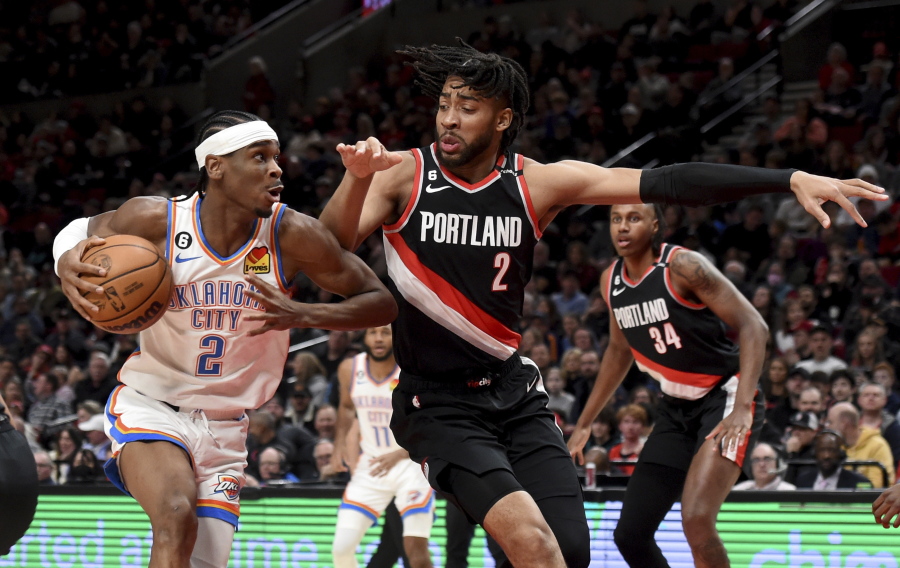 Oklahoma City Thunder guard Shai Gilgeous-Alexander, left, drives to the basket on Portland Trail Blazers forward Trendon Watford (2) during the first half of an NBA basketball game in Portland, Ore., Friday, Feb. 10, 2023.
