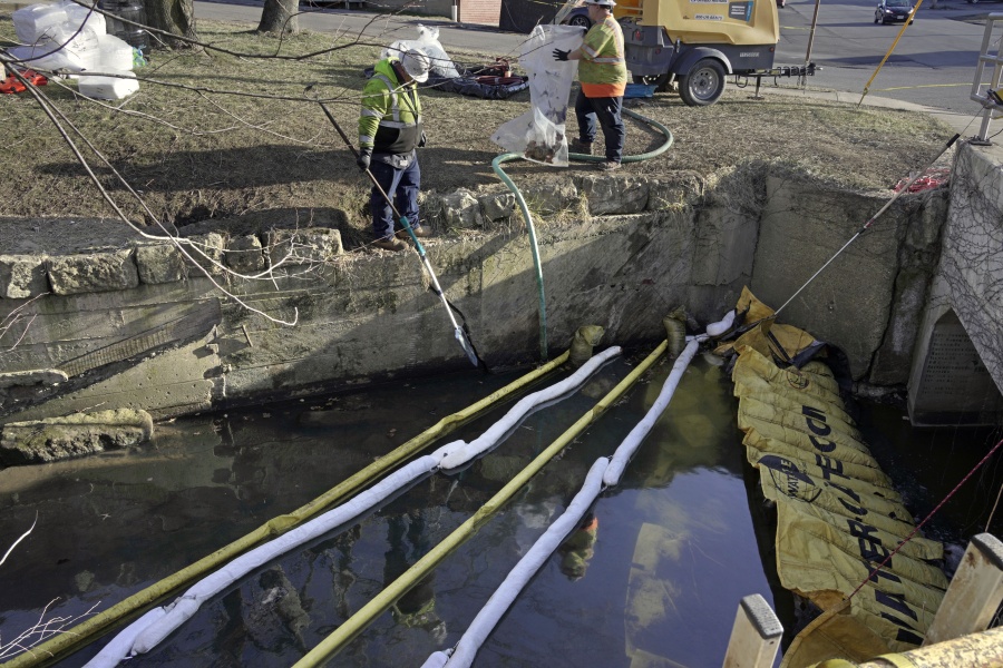Booms are placed in a stream that flows through the center of East Palestine, Ohio, Wednesday, Feb. 15, 2023, as cleanup continues following the derailment of a Norfolk Southern freight train over a week ago. (AP Photo/Gene J.