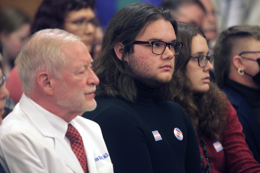 Adam Kellogg, center, a University of Kansas student and transgender man, follows a Kansas Senate health committee hearing on legislation aimed at preventing gender-affirming care for minors, Tuesday, Feb. 14, 2023, at the Statehouse in Topeka, Kan. The Republican-controlled Kansas Legislature is also considering a measure to define male and female in state law in such a way that it could prevent transgender men and women from changing their driver's licenses and birth certificates.