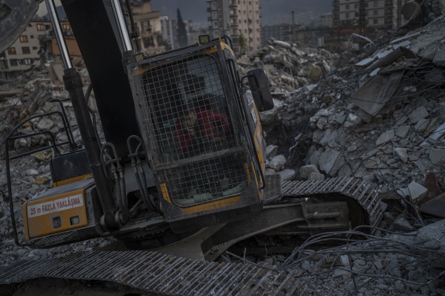An excavator driver waits for a rescue team to recover the body of an earthquake victim from a collapsed building in Antakya, southeastern Turkey, Sunday, February 12, 2023. Six days after earthquakes killed tens of thousands in Syria and Turkey, sorrow and disbelief are turning to anger and tension. Many in Turkey have a sense that there has been an ineffective, unfair and disproportionate response to the historic disaster.