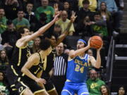 UCLA guard Jaime Jaquez Jr. (24) looks to pass the ball as Oregon's Nate Bittle (32), left, Kel'el Ware, middle front, and guard Rivaldo Soares, middle rear, defend during the first half of an NCAA college basketball game Saturday, Feb. 11, 2023, in Eugene, Ore.