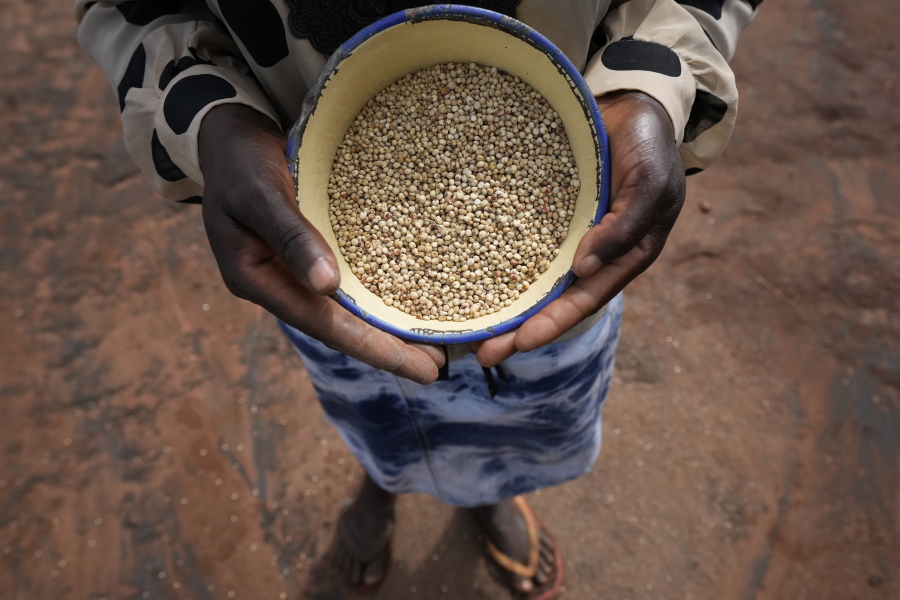 Maria Chagwena, a millet farmer, holds a plate with millet grains outside her house in Zimbabwe's arid Rushinga district, northeast of the capital Harare, on Wednesday, Jan, 18, 2023. With concerns about war, drought and the environment raising new worries about food supplies, the U.N.'s Food and Agricultural Organization has christened 2023 as the "Year of Millets" -- grains that have been cultivated in all corners of the globe for millennia but have been largely pushed aside.