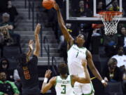 Oregon center N'Faly Dante (1) blocks the shot of Southern California guard Boogie Ellis (5) as guard Keeshawn Barthelemy (3) watches during the first half of an NCAA college basketball game Thursday, Feb. 9, 2023, in Eugene, Ore.