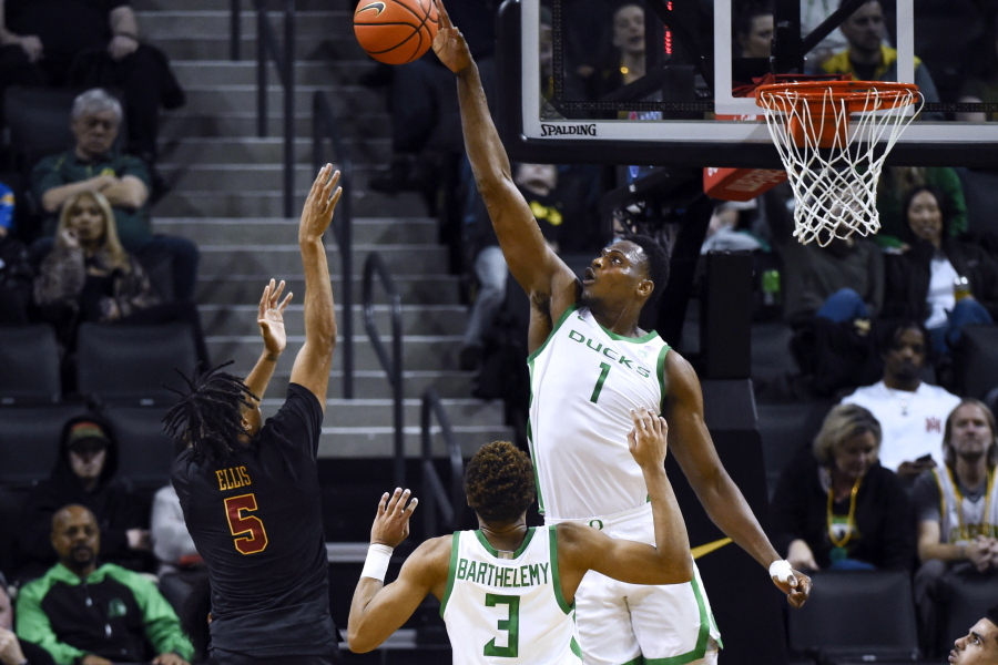 Oregon center N'Faly Dante (1) blocks the shot of Southern California guard Boogie Ellis (5) as guard Keeshawn Barthelemy (3) watches during the first half of an NCAA college basketball game Thursday, Feb. 9, 2023, in Eugene, Ore.
