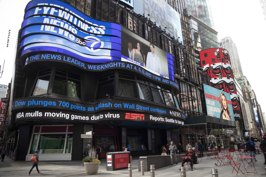 FILE - An electronic ticker displays news Wednesday, March 11, 2020, in New York's Times Square. A new survey released Wednesday, Feb. 15, 2023, shows fully half of Americans indicate they believe national news organizations intend to mislead, misinform or persuade the public to adopt a point of view.