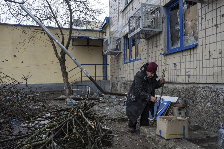 Emilia Budskaya, a local resident who decided to stay in the city breaks dead tree branches to heat her basement in the frontline city of Vuhledar, Ukraine, Saturday, Feb. 25, 2023.