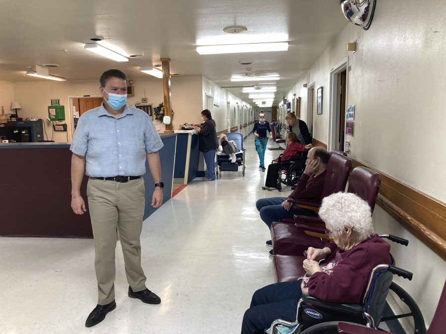 Tim Corbin, left, the administrator of Truman Lake Manor, passes through the hallway of the nursing home on Feb. 14, 2023, in Lowry, Mo. The facility was cited in December for a violation of the federal vaccination requirement for health care workers but subsequently came into compliance. Corbin believes it's time for the vaccination mandate to end. (AP Photo/David A.
