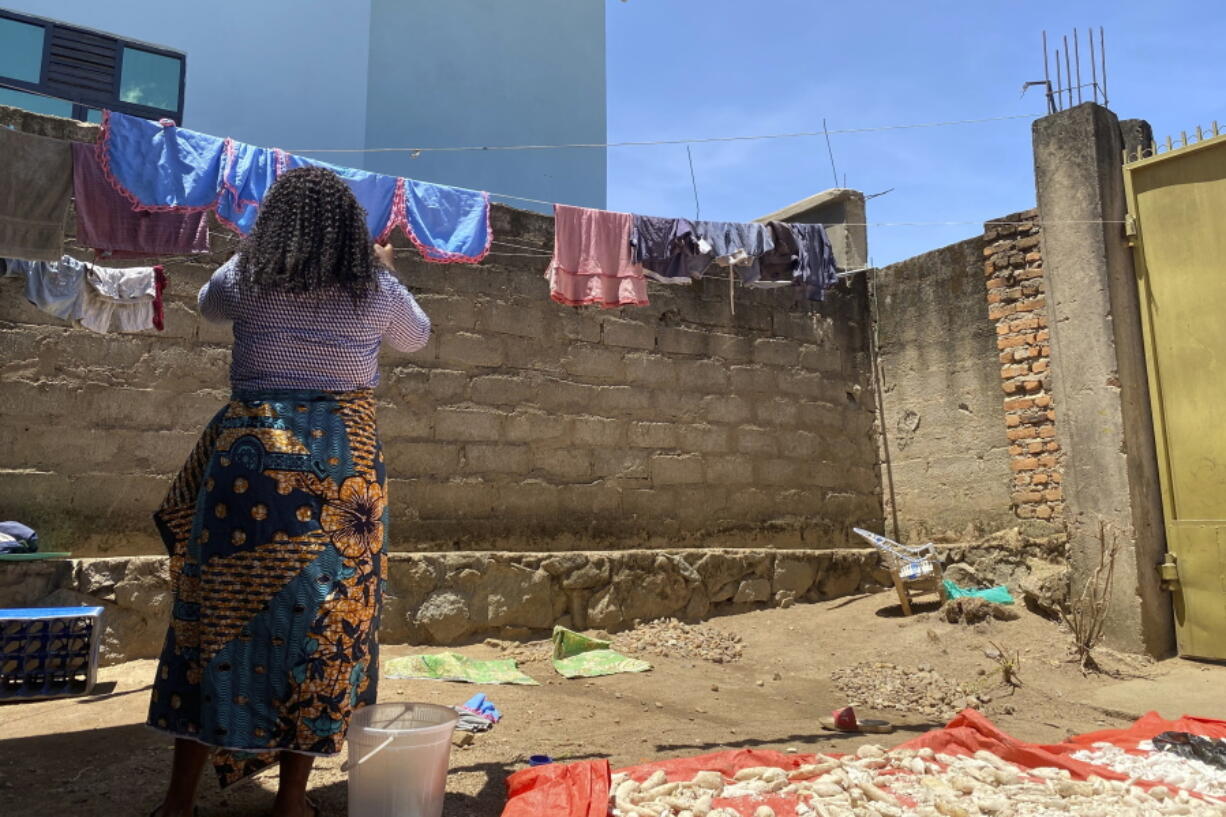 FILE - Reby hangs laundry outside her home in Beni, eastern Congo, on Saturday, May 1, 2021, who met WHO Dr Boubacar Diallo, of Canada in 2019, when he came into a mobile phone shop where she was working. A confidential U.N. report into the alleged missteps by senior World Health Organization staffers in how they handled a sexual misconduct case during an Ebola outbreak in Congo found their response didn't violate the agency's policies because of what some officials described as a "loophole."  The report was submitted to WHO last month and wasn't released publicly.