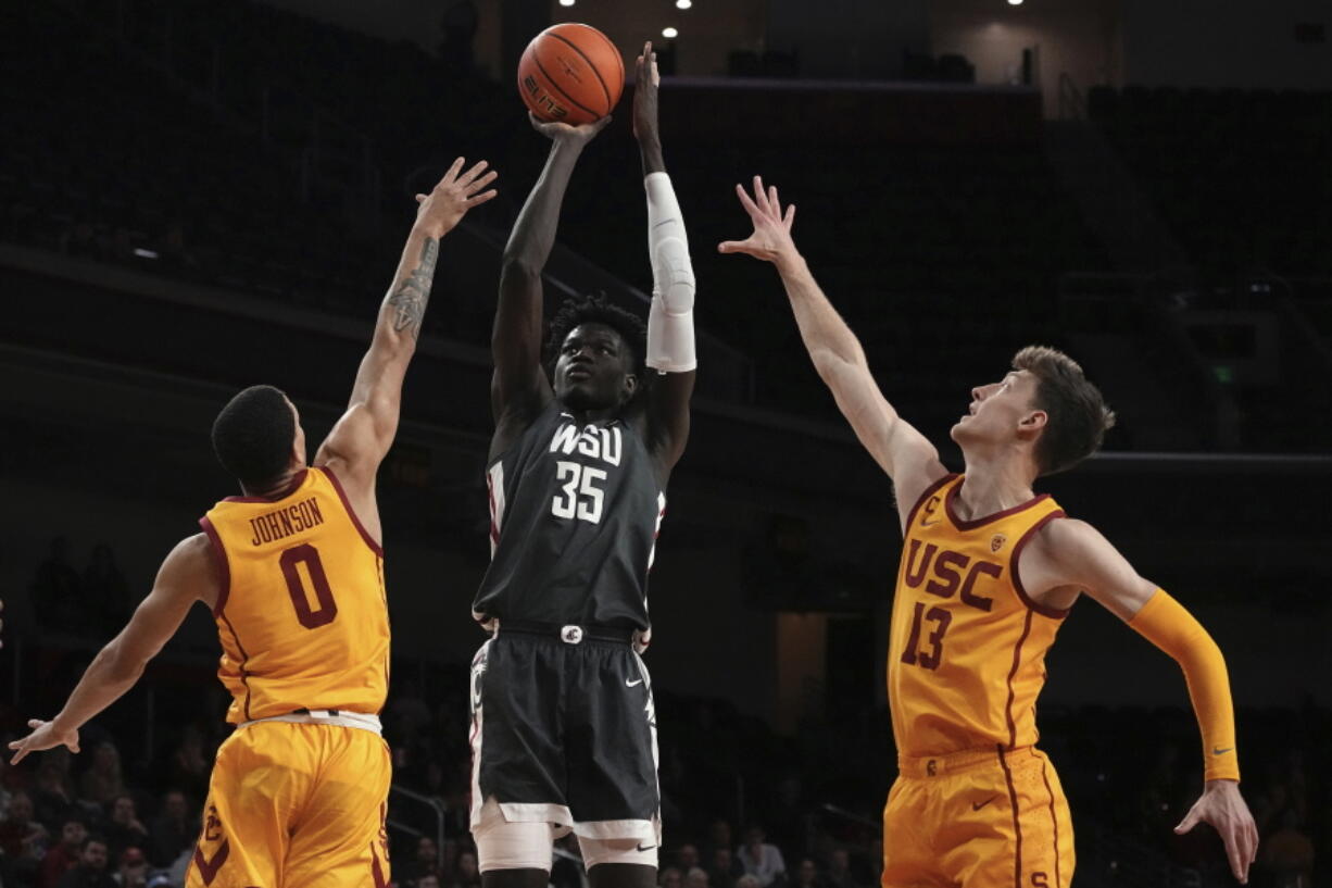Washington State forward Mouhamed Gueye, center, shoots as Southern California forward Kobe Johnson, left, and guard Drew Peterson defend during the first half of an NCAA college basketball game Thursday, Feb. 2, 2023, in Los Angeles. (AP Photo/Mark J.