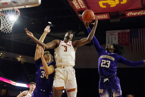 Southern California forward VIncent Iwuchukwu (3) works for a rebound between Washington center Braxton Meah (34) and guard Keyon Menifield (23) during the second half of an NCAA college basketball game Saturday, Feb. 4, 2023, in Los Angeles. (AP Photo/Marcio Jose Sanchez)
