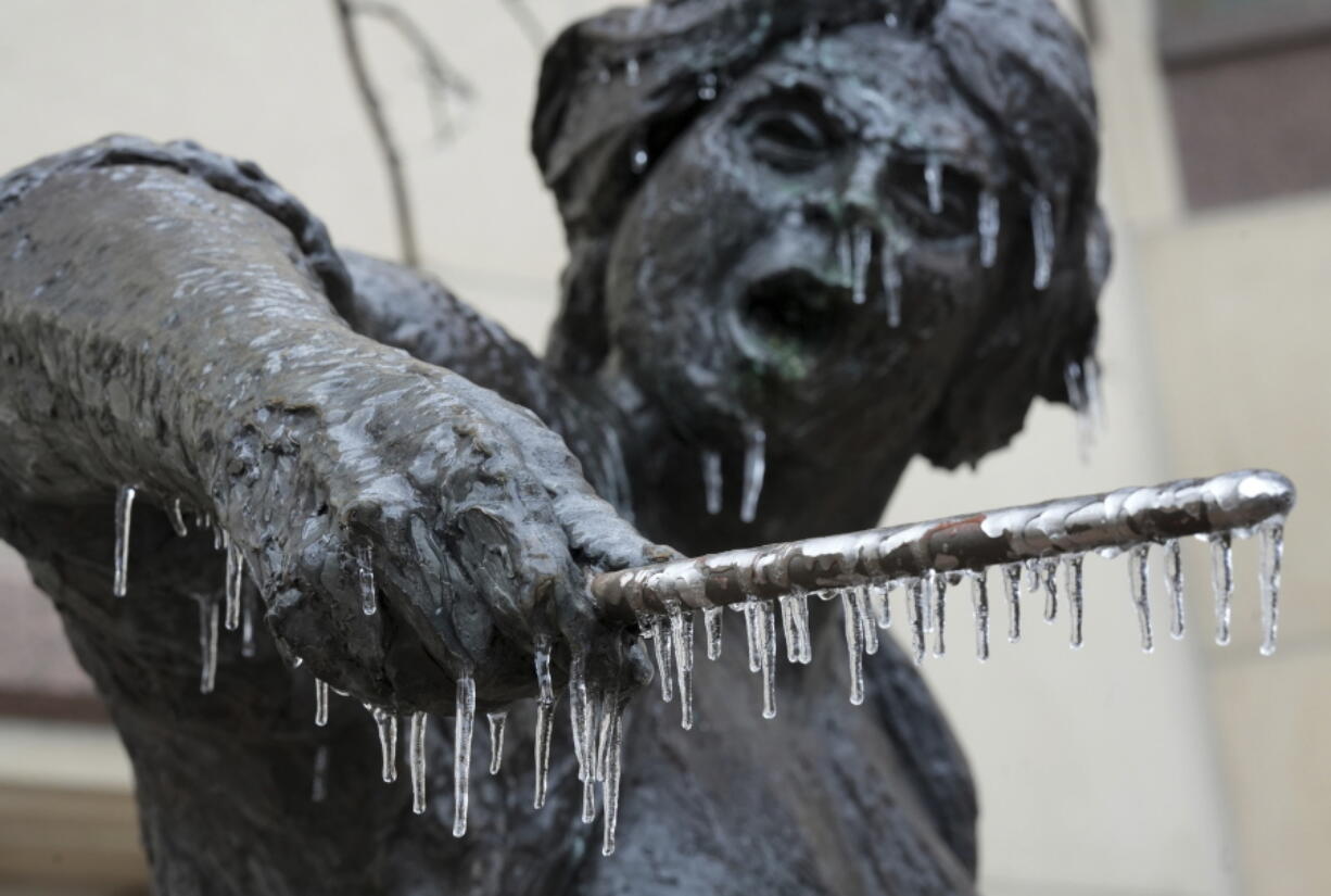 Icicles hang from the Angelina Eberly statue in downtown Austin, Texas, during a winter storm on Wednesday, Feb. 1, 2023.