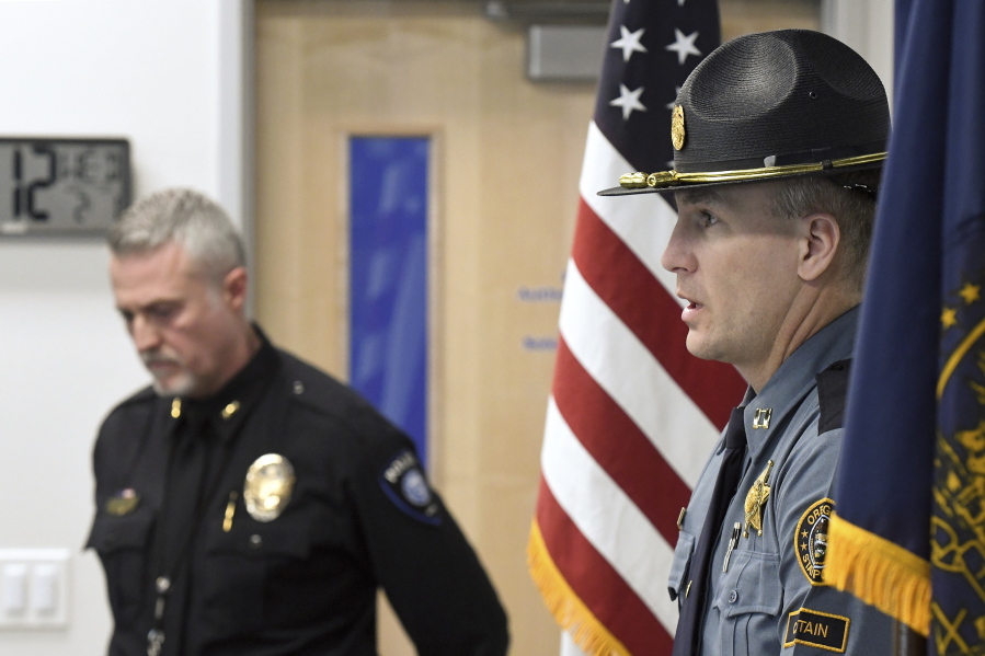 Oregon State Police, Capt. Kyle Kennedy, right, speaks to reporters during a news conference at Grants Pass police headquarters on Wednesday, Feb. 1, 2023, in Grants Pass, Ore. Kennedy, and Grants Pass Police Chief Warren Hensman, left, recounted the series of events in recent days that led to an armed standoff with a suspect in a violent kidnapping in Oregon who died after shooting himself, authorities said. Police now believe he also murdered two people in Sunny Valley, Ore.
