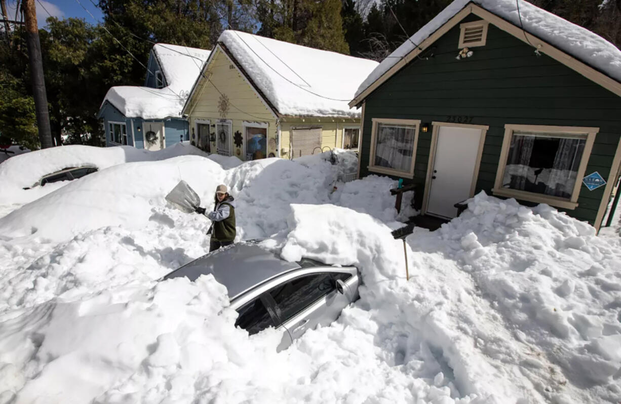 Kadyn Wheat, 14, on Tuesday shovels snow to free the family car that is entombed in the driveway after successive snow storms paralyzed the San Bernardino Mountain community.