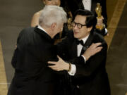 Ke Huy Quan, right, accepts the award for Best Picture for "Everything Everywhere All at Once" from Harrison Ford onstage during the 95th Annual Academy Awards at Dolby Theatre on March 12, 2023, in Hollywood, California.
