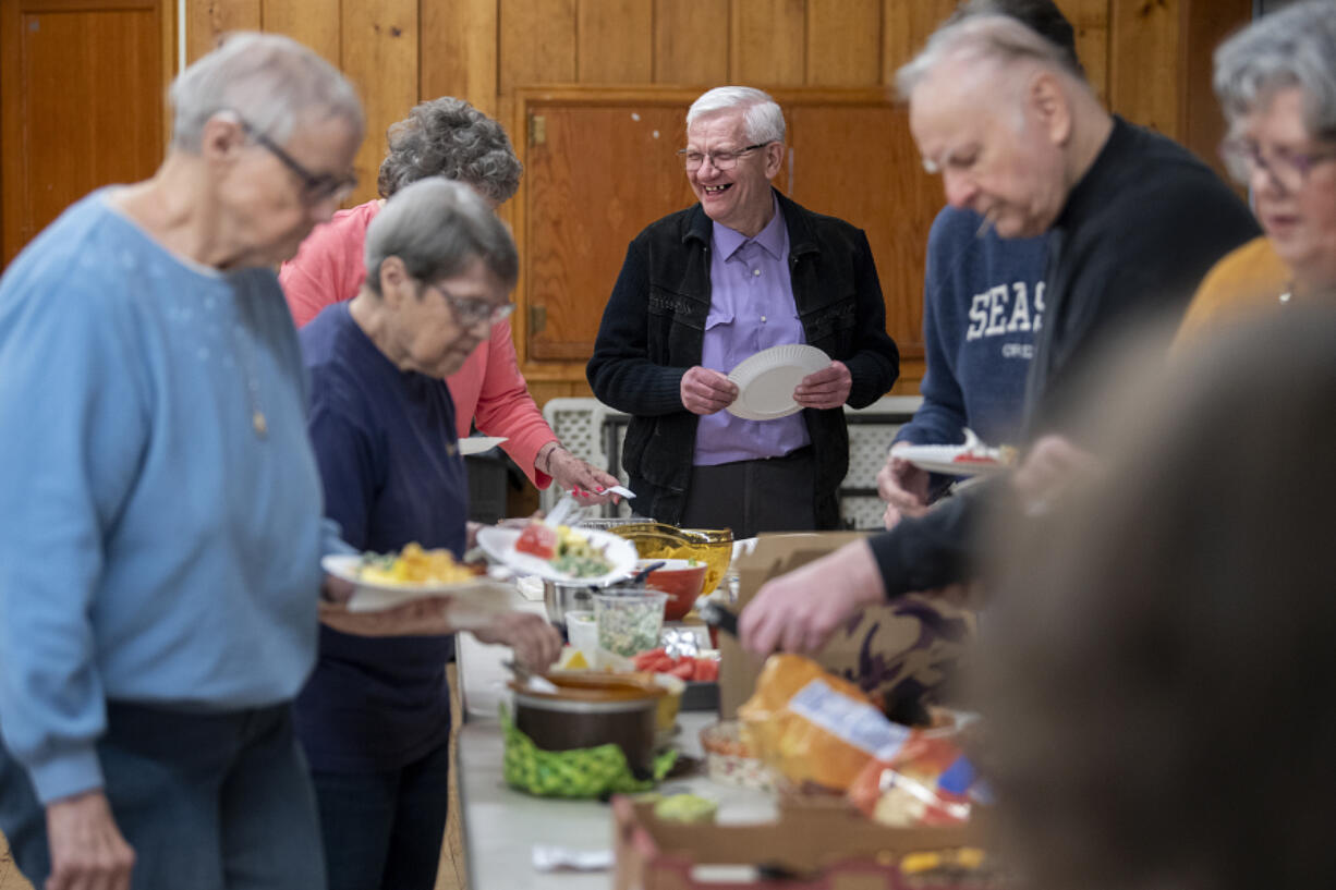 Wes Jedrzejewski, center in purple shirt, chats with fellow members of Single Seniors at the March potluck at St. Luke's - San Lucas Episcopal Church in Vancouver.