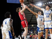 Camas sophomore guard Beckett Currie shoots over the defense of Curtis junior guard Devin Whitten and Curtis sophomore forward Xavier Ahrens during a Class 4A State quarterfinal game on Thursday, March 2, 2023, at the Tacoma Dome.