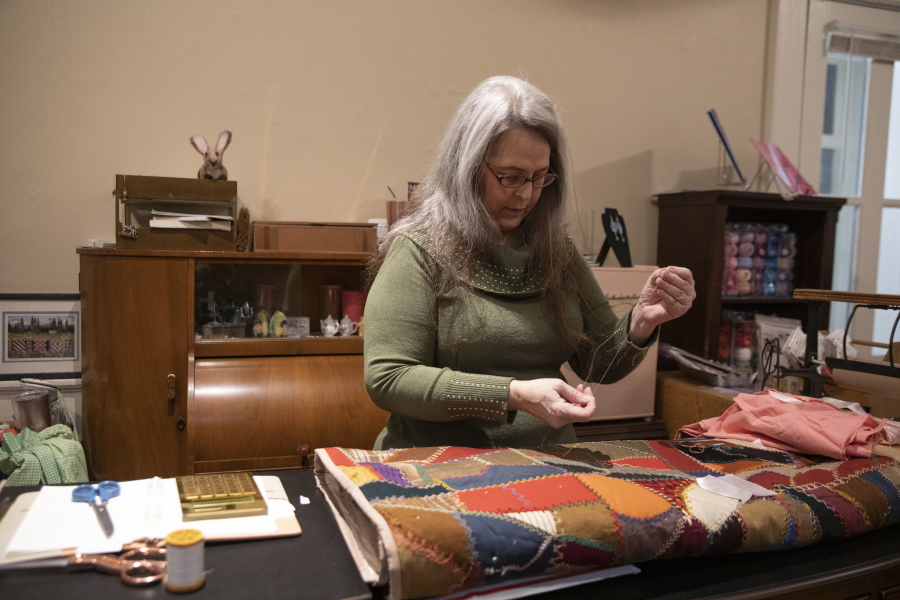 Miki Landis repairs a frayed section of quilt at her sewing store, The Enchanted Rose Emporium. She teaches a variety of workshops to help people get comfortable with basic repairs.