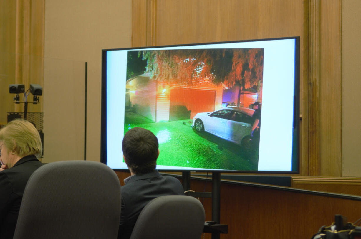 Jacob Cantrell, right, looks at a police photo of his east Vancouver driveway during his attempted murder and assault trial Tuesday in Clark County Superior Court. Cantrell's attorney said he shot another man in his driveway after the man smashed Cantrell's car's windows with a shovel.